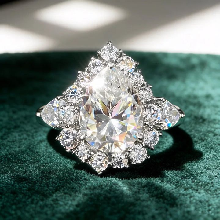 Pear-cut diamond ring with prong-set center stone and round halo border