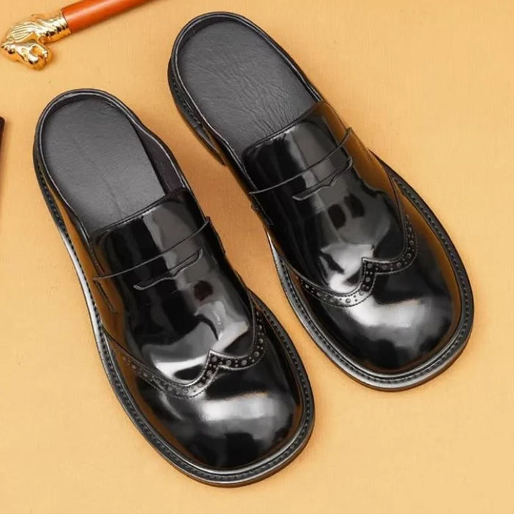 Black glossy leather men’s slip-on mules with strap and wingtip-style paneling
