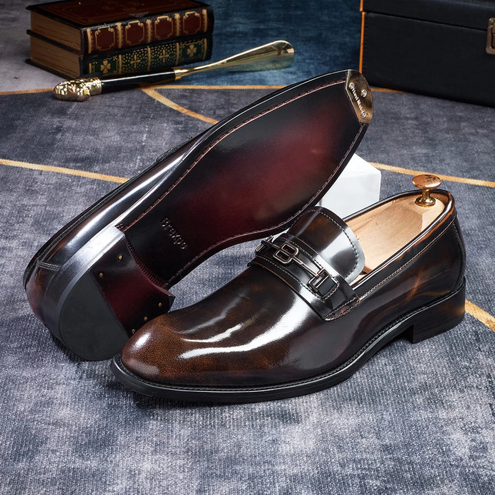 Brown pointed-toe leather loafer with double buckle strap, glossy finish