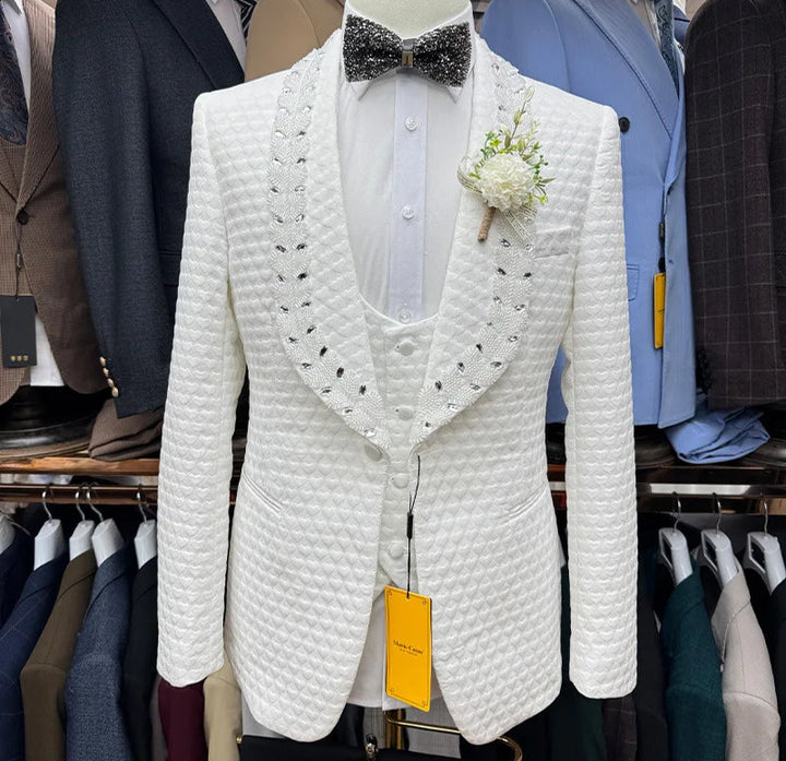 White textured tuxedo jacket with a bow tie and flower on a mannequin against a background of other suits.