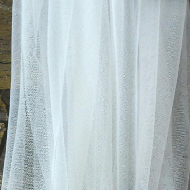 White tulle bridal veil close-up with subtle textured pattern and sheer fabric