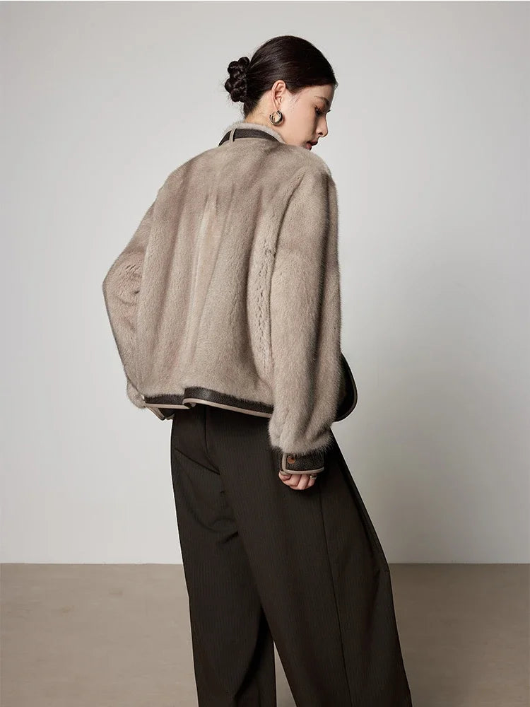 Back view of light taupe women's short mink fur coat with dark hem trim