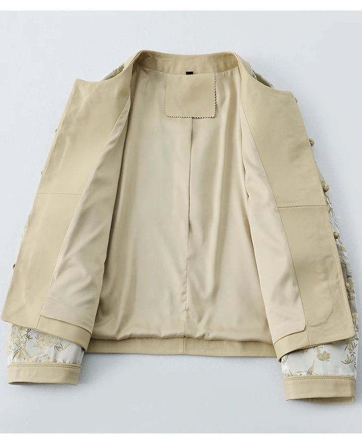 Cream women’s coat with stand collar, flap pockets, and gold button trim