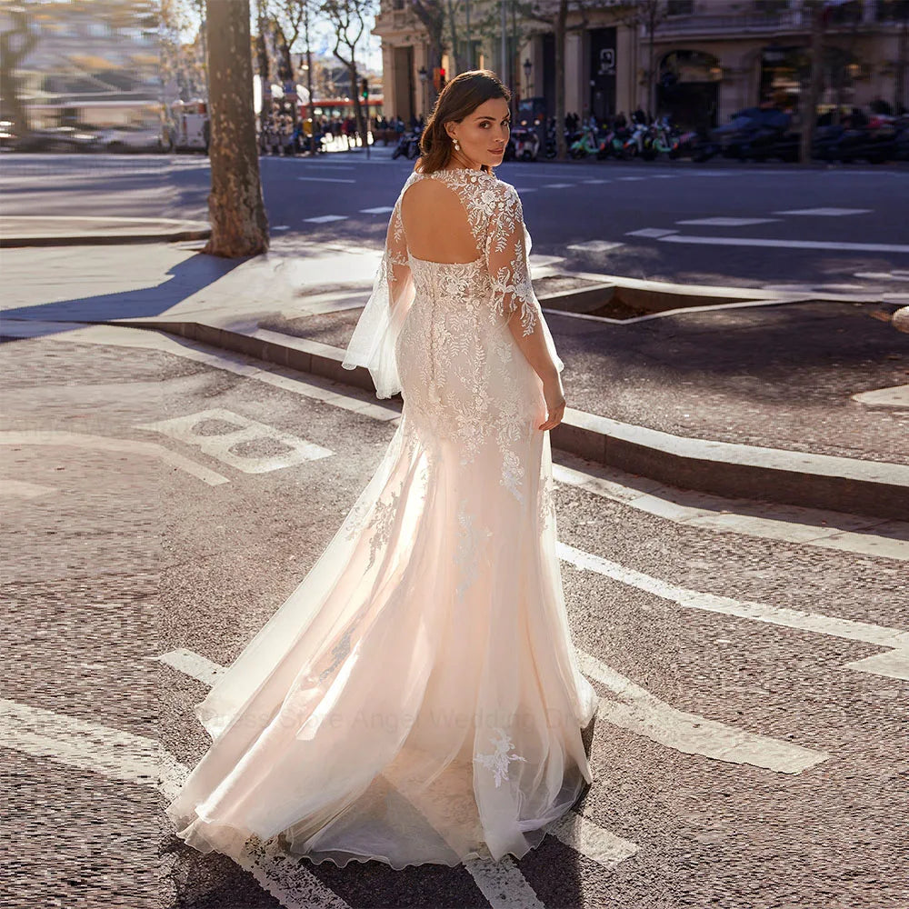 Ivory lace bridal gown with illusion neckline, long sleeves, and flowing tulle skirt