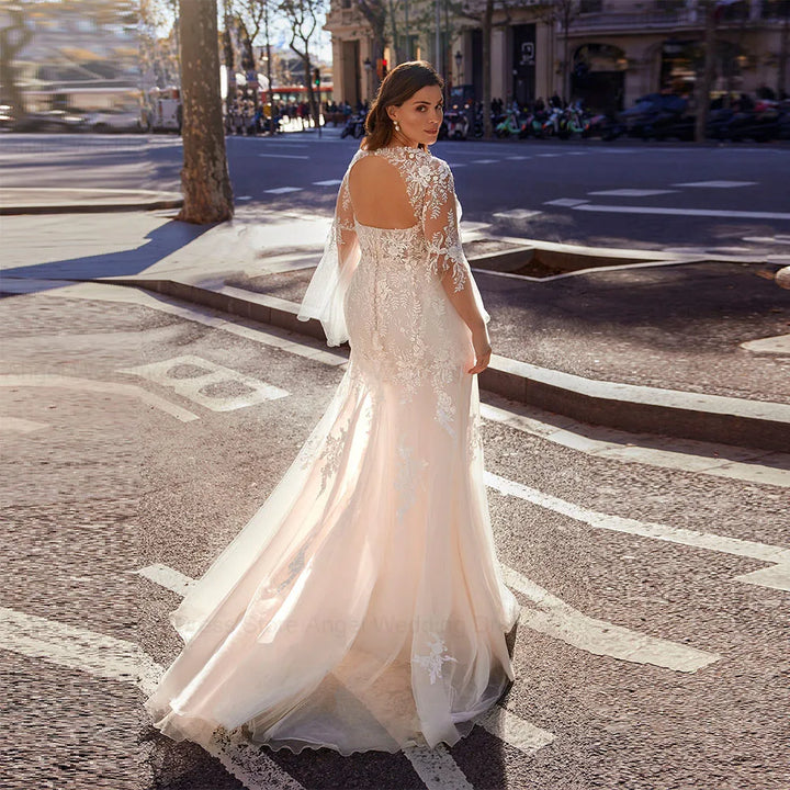 Ivory lace bridal gown with illusion neckline, long sleeves, and flowing tulle skirt