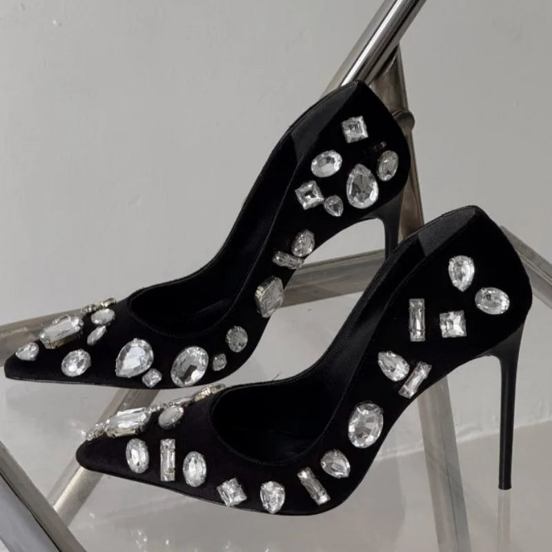 Black satin crystal heel pumps, close side view of jeweled toe and stiletto heel
