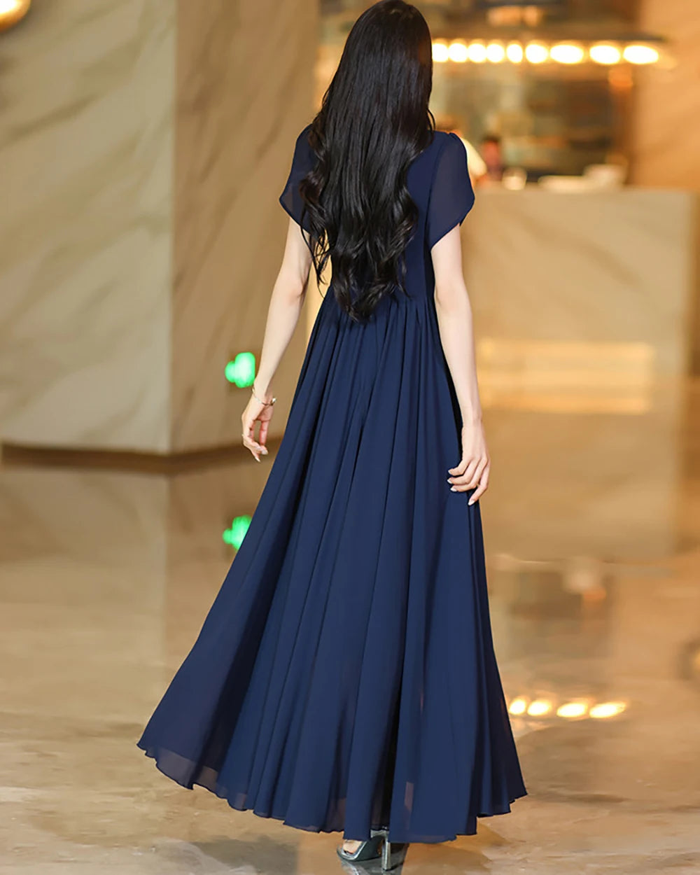 Navy A-line maxi skirt viewed from behind, with pleated drape