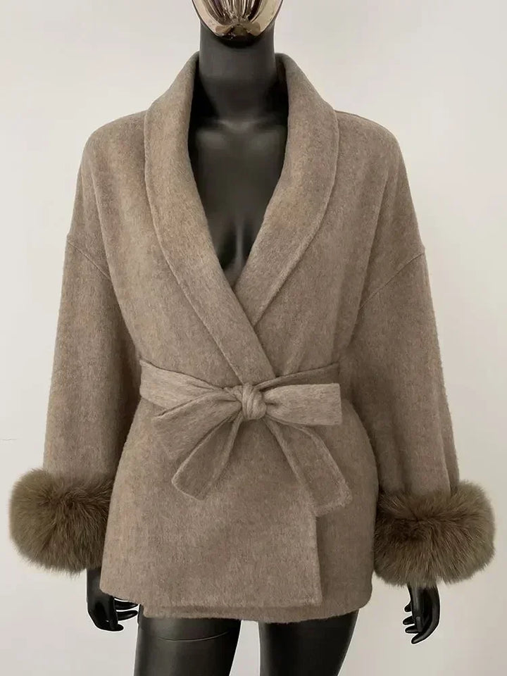 Camel tan coat with wide V lapels, fabric waist tie belt, and faux fur cuff trim