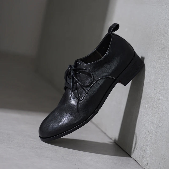 Black lace-up leather flat shoes with low block heel and rounded toe
