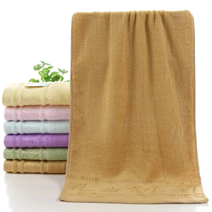 Bamboo bath towel set: brown towel with decorative stitched hem and rolled towels
