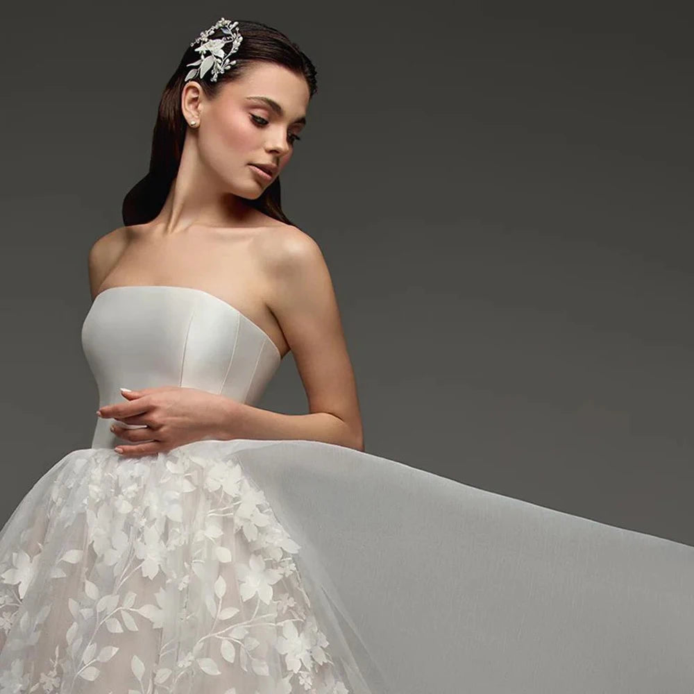 Strapless bridal gown bodice close-up with sweetheart satin top and floral lace skirt
