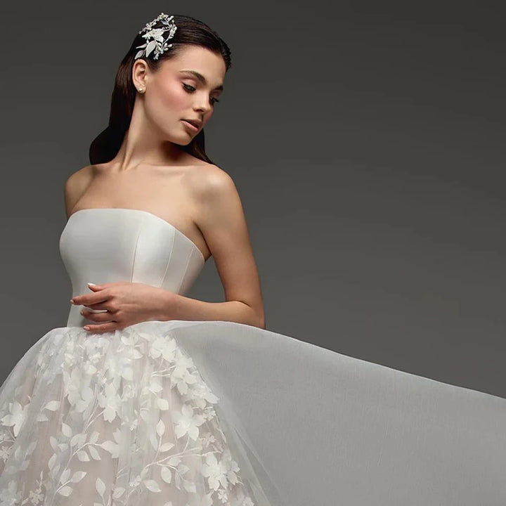 Strapless bridal gown bodice close-up with sweetheart satin top and floral lace skirt