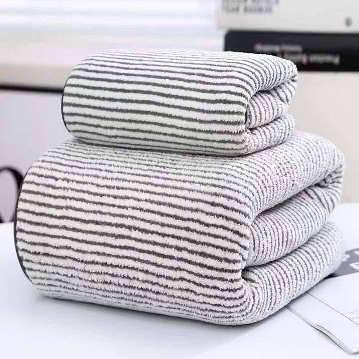 Striped towel set, two folded plush towels with rounded edges and gray stripes