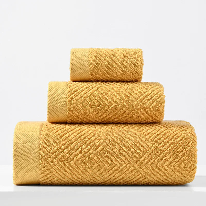 3-pack cotton towel set in mustard yellow, folded in three stacked rolls