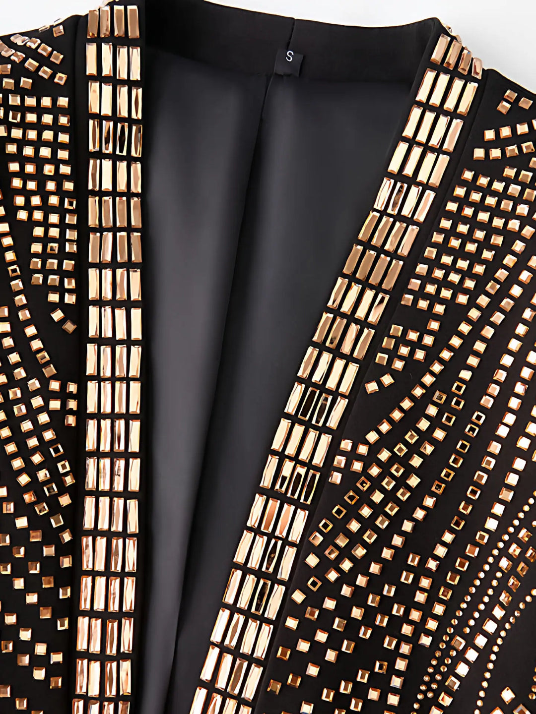 Close-up of gold rhinestone trim on black blazer lapels and collar