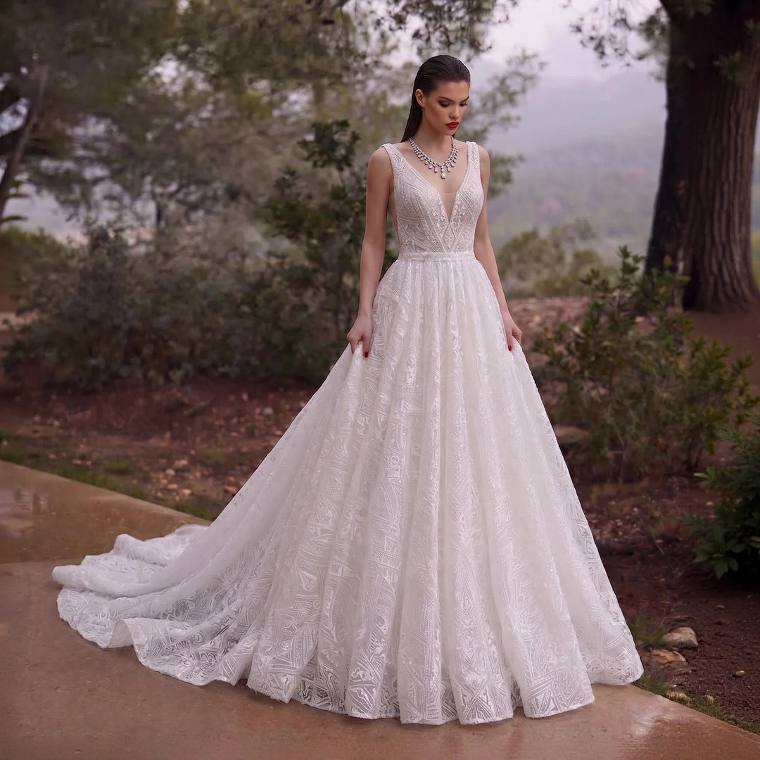 Off-white bridal gown with V-neck sleeveless bodice, lace applique, and full flowing skirt