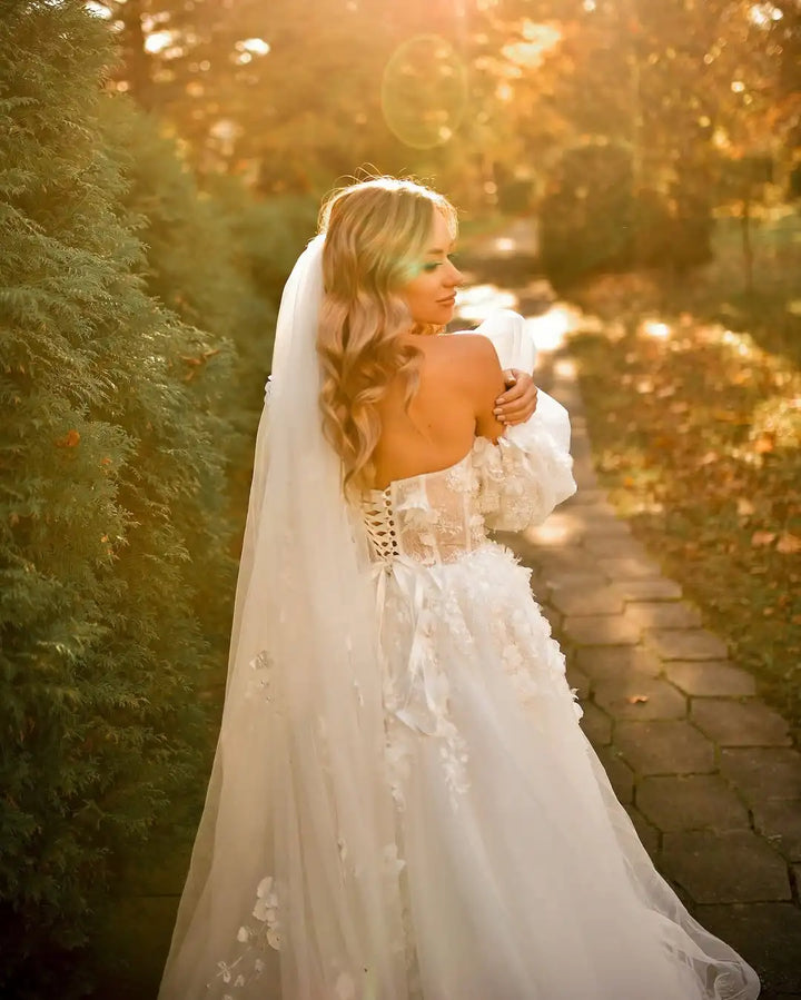 Ivory off-shoulder bridal gown with sheer veil and lace detailing, side view