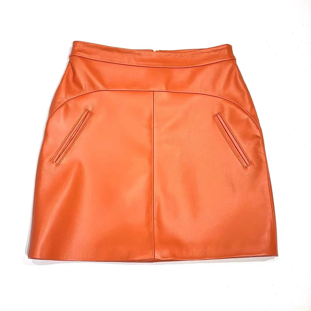 Orange high-waist leather mini skirt with front center seam and pocket zippers