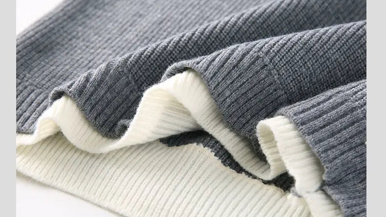 Close-up of gray sweater knit pattern with ribbed cuffs and cream trim