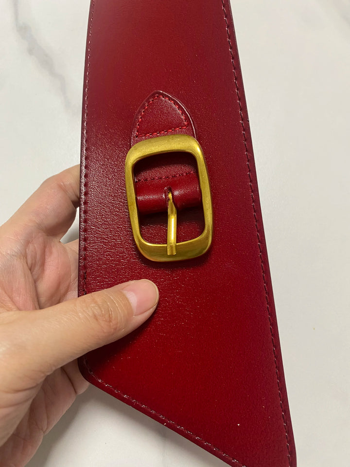 Red leather corset belt with oval gold buckle, stitched edge, strap end detail