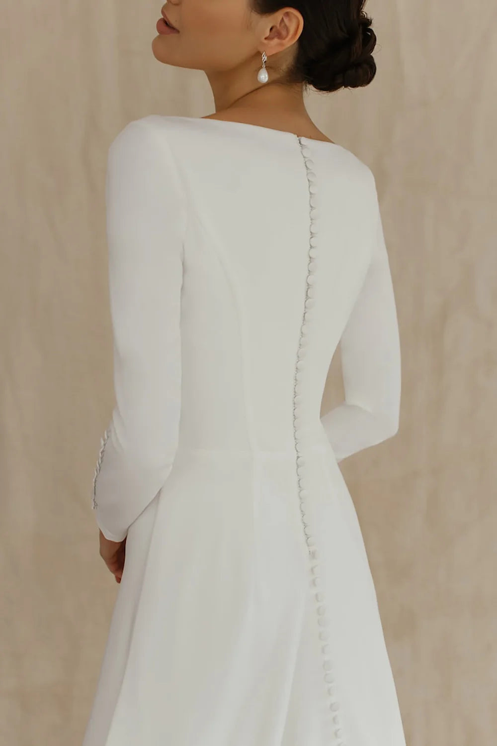 White A-line wedding dress back view with long sleeves and scalloped trim