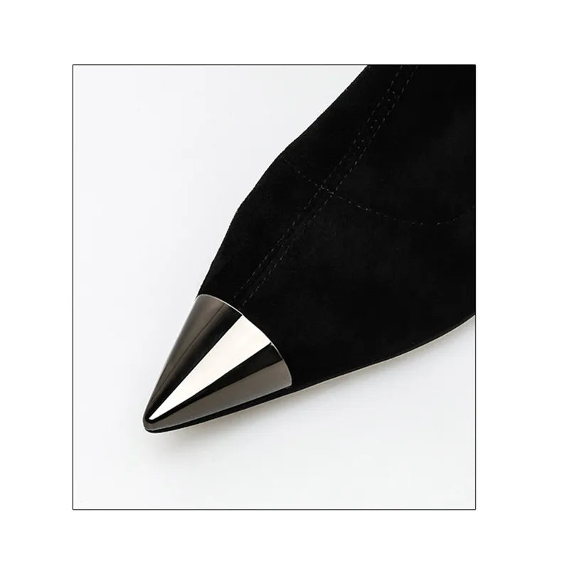 Close-up of black faux suede boot with pointed toe and metallic heel tip.