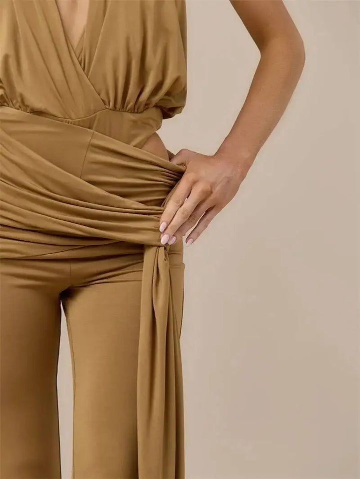 Ruched waist detail on brown backless halter jumpsuit with tied fabric panel