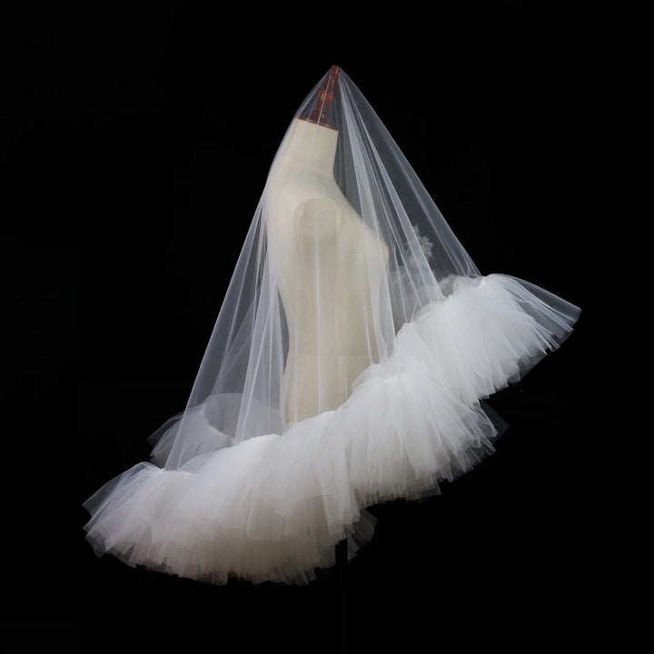 White tulle bridal veil with layered ruffle trim, angled view