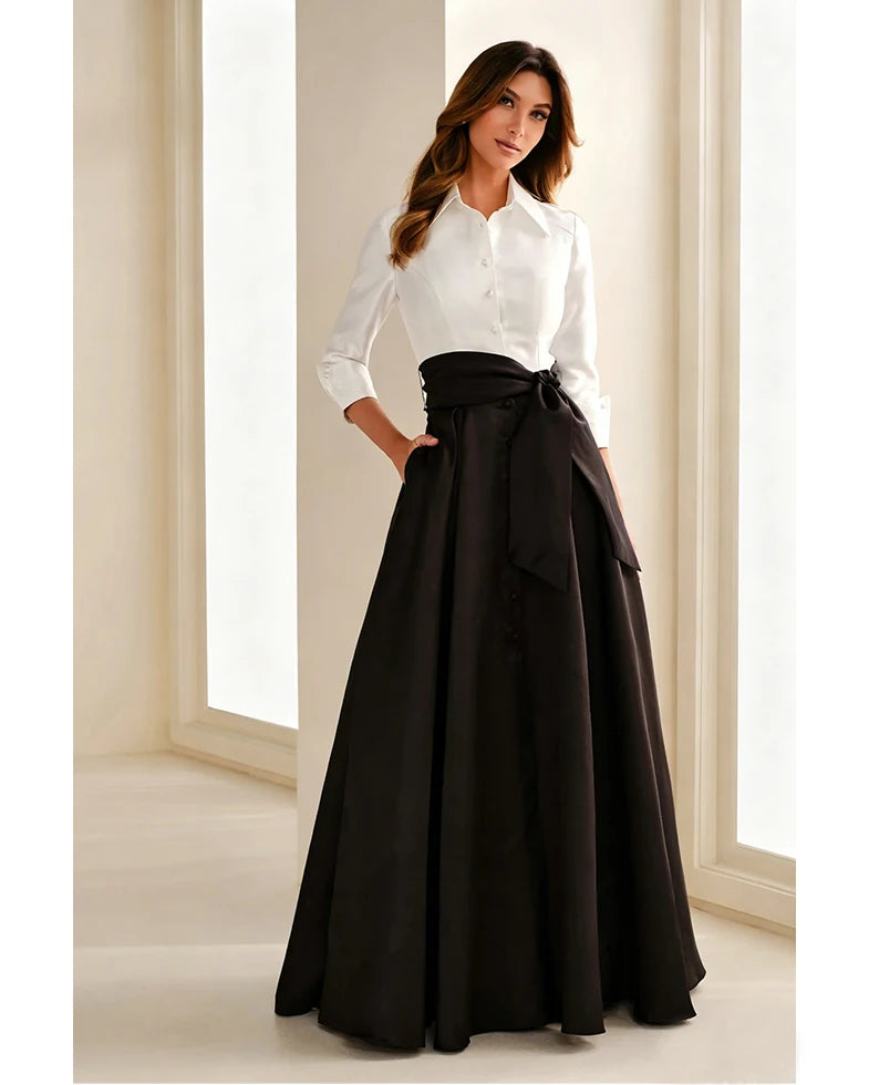 Black chiffon gown with bow belt and pleated full skirt, paired with white button blouse.