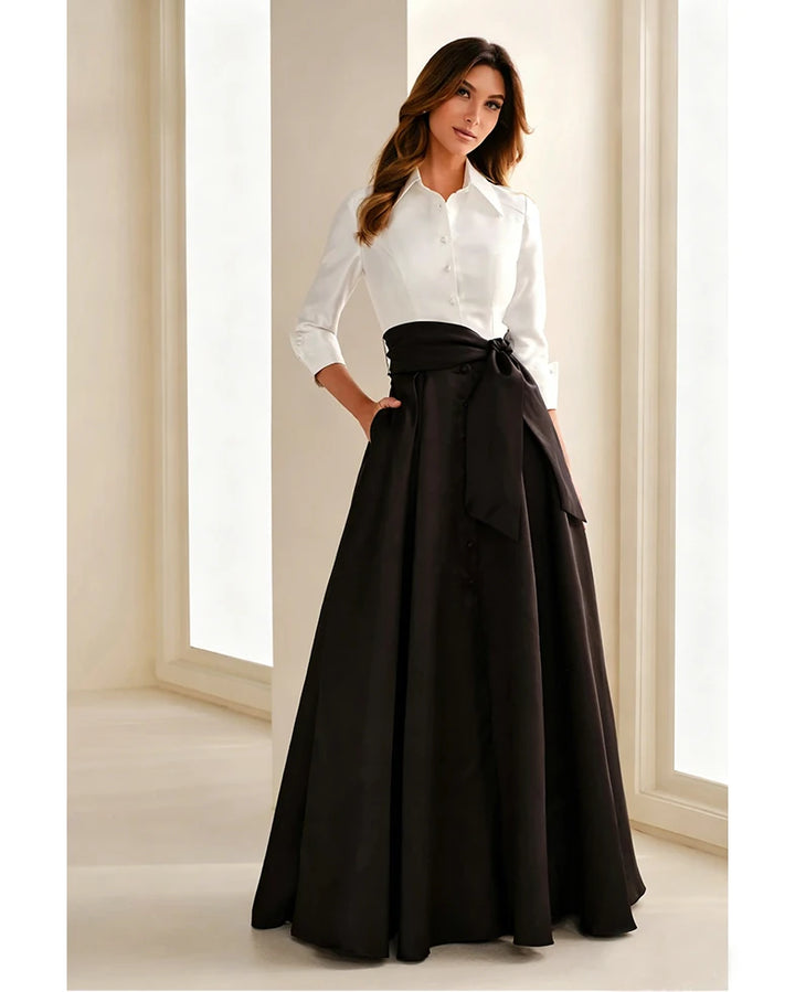 Black chiffon gown with bow belt and pleated full skirt, paired with white button blouse.