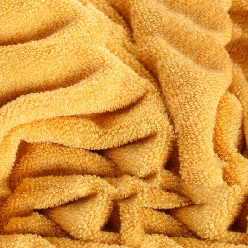 Golden yellow terry towel texture with dense looped pile, folded layers