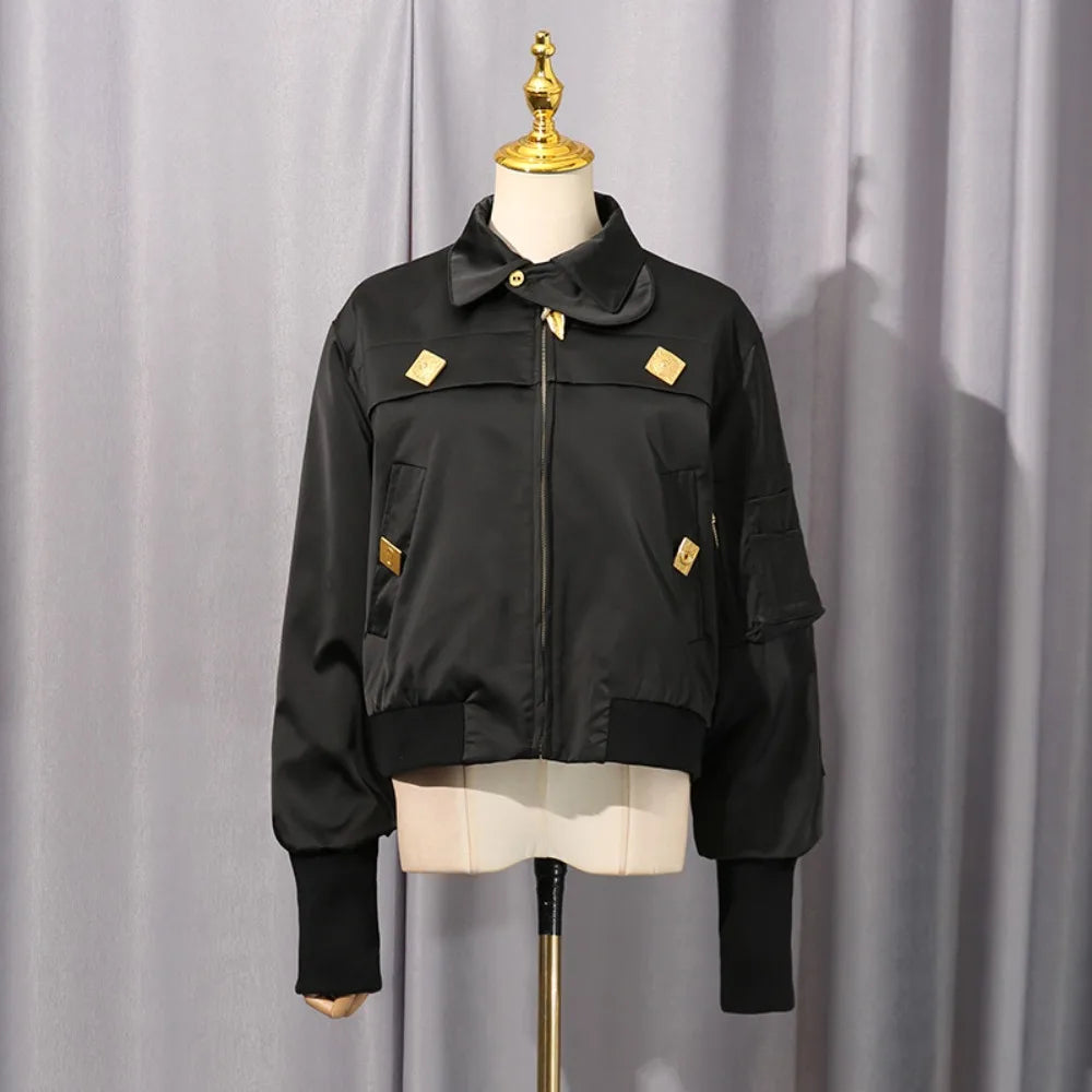 Black cropped coat on mannequin, zip front, stand collar, gold accents and patch pockets.