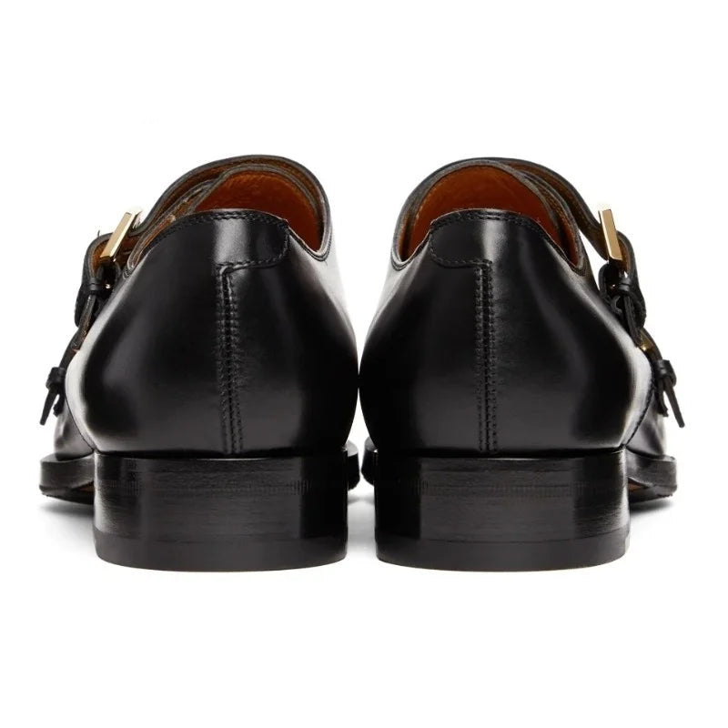 Black leather shoes with brown soles on a white background, branded 'Stiglitz'.
