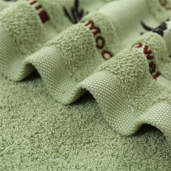 Green towel corner with red embroidered lettering and leaf print band