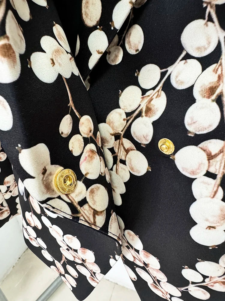 Black blazer jacket sleeve with gold round button detail and cream oval chain print