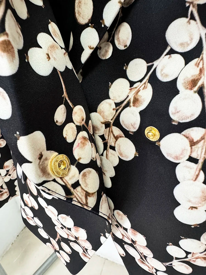 Black blazer jacket sleeve with gold round button detail and cream oval chain print