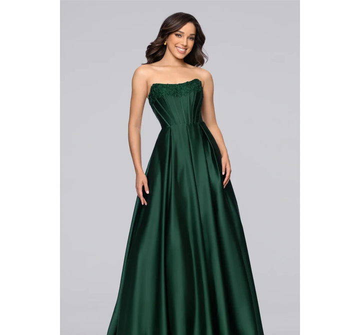 Woman wearing a strapless green evening gown on a gray background