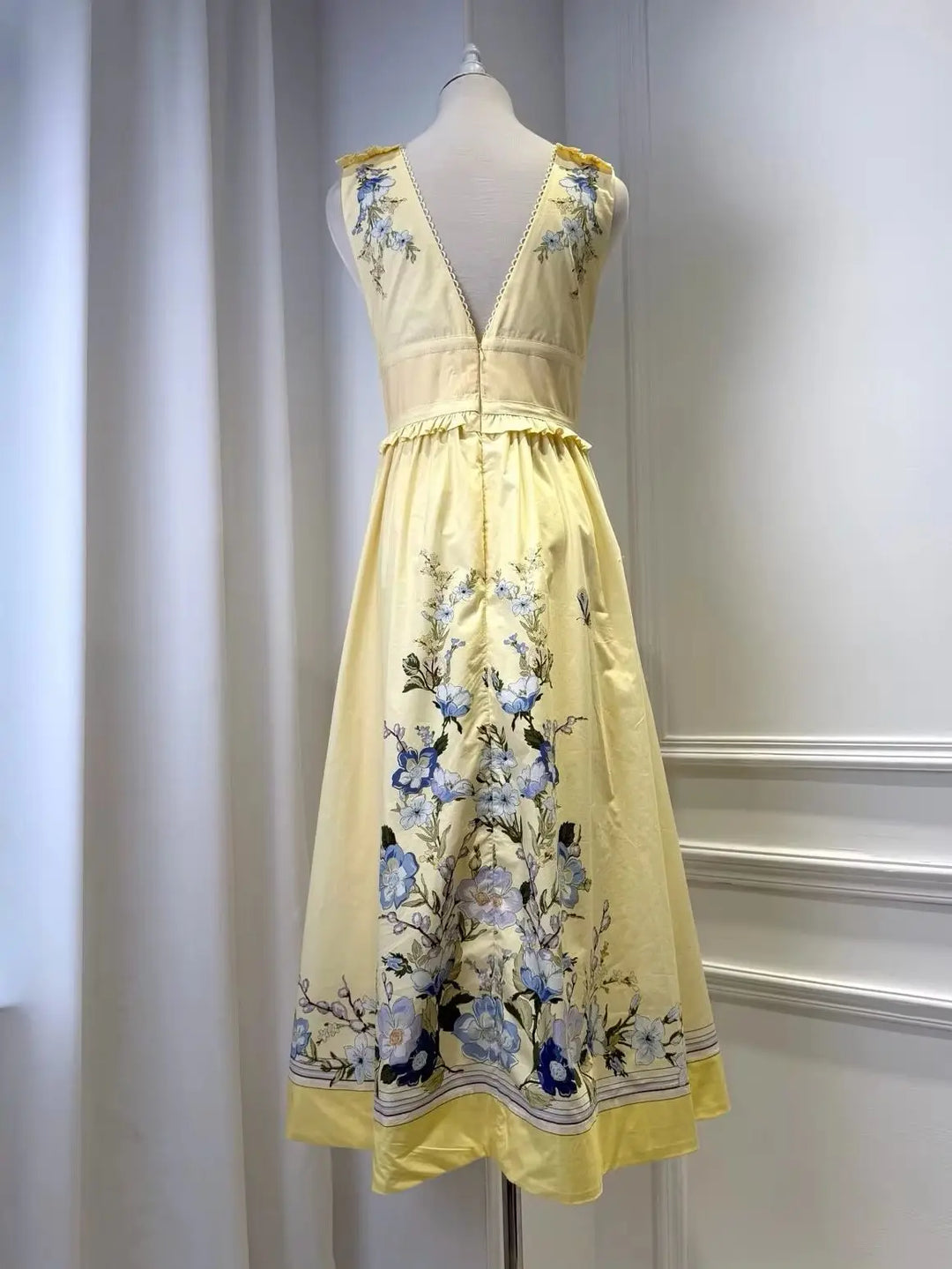 Light yellow floral midi dress with shoulder ruffles, V-neck, and gathered waist