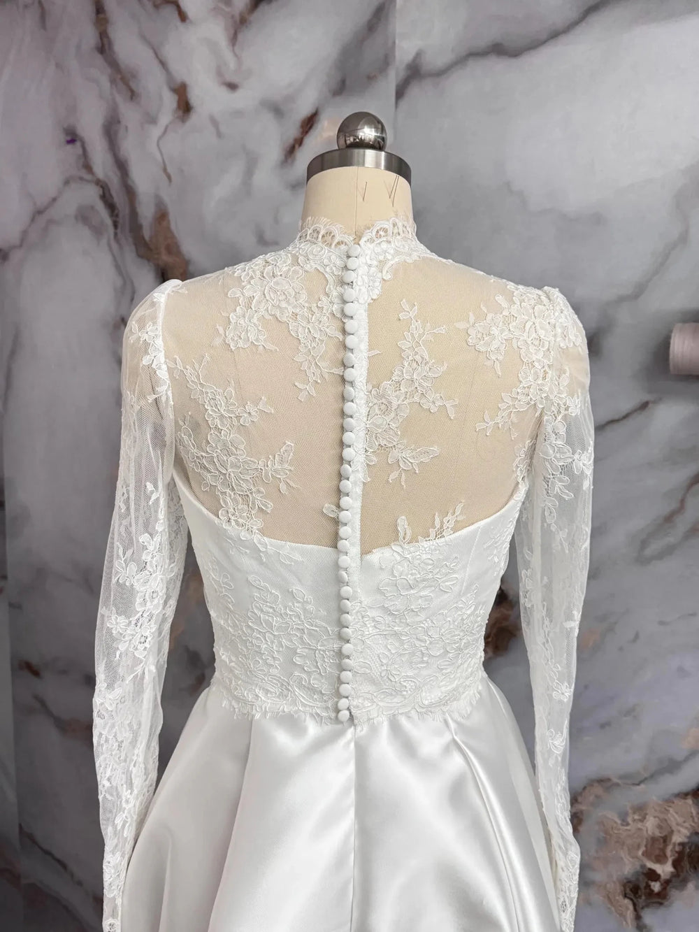 Off-white lace bridal jacket back with vertical button line and long sheer sleeves