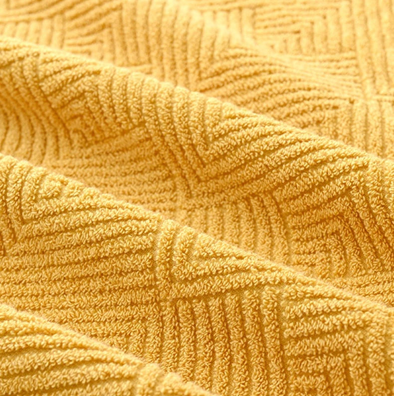 Close-up of mustard yellow cotton towel texture with raised chevron stitching