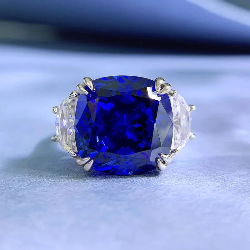 Sterling silver statement ring with blue oval center stone and clear side accents