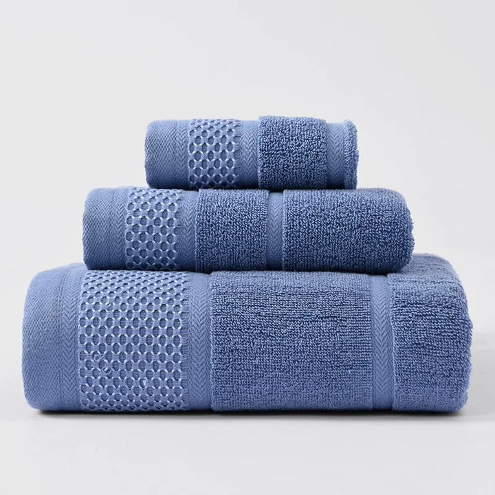 3-piece thick cotton towel set in blue, folded towels with textured waffle weave bands.