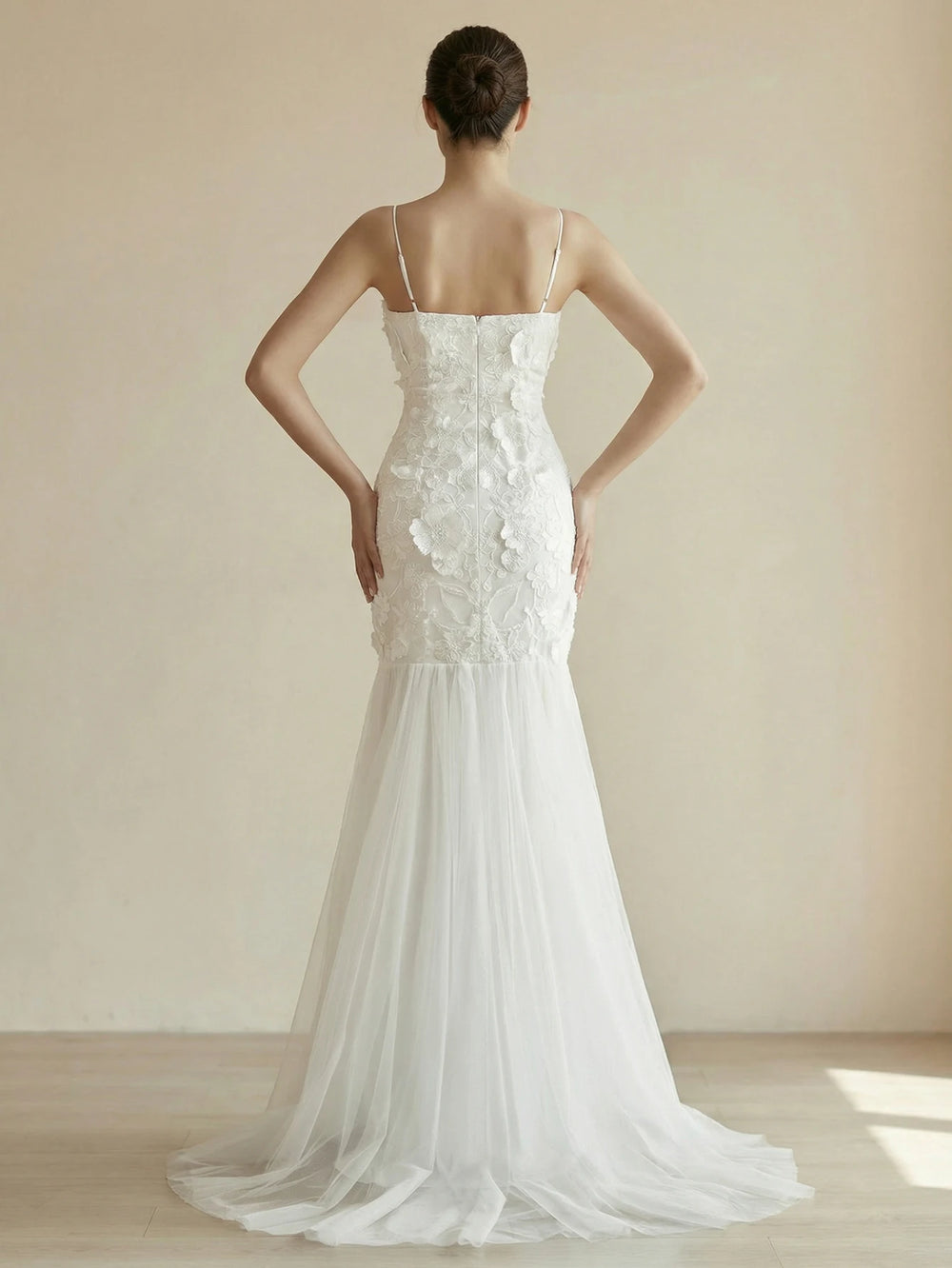 White appliqué bridal gown with spaghetti straps and tulle train