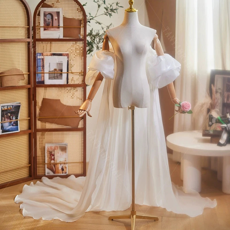 Ivory organza bridal cape with ruffled shoulder cuffs and flowing train-like drape