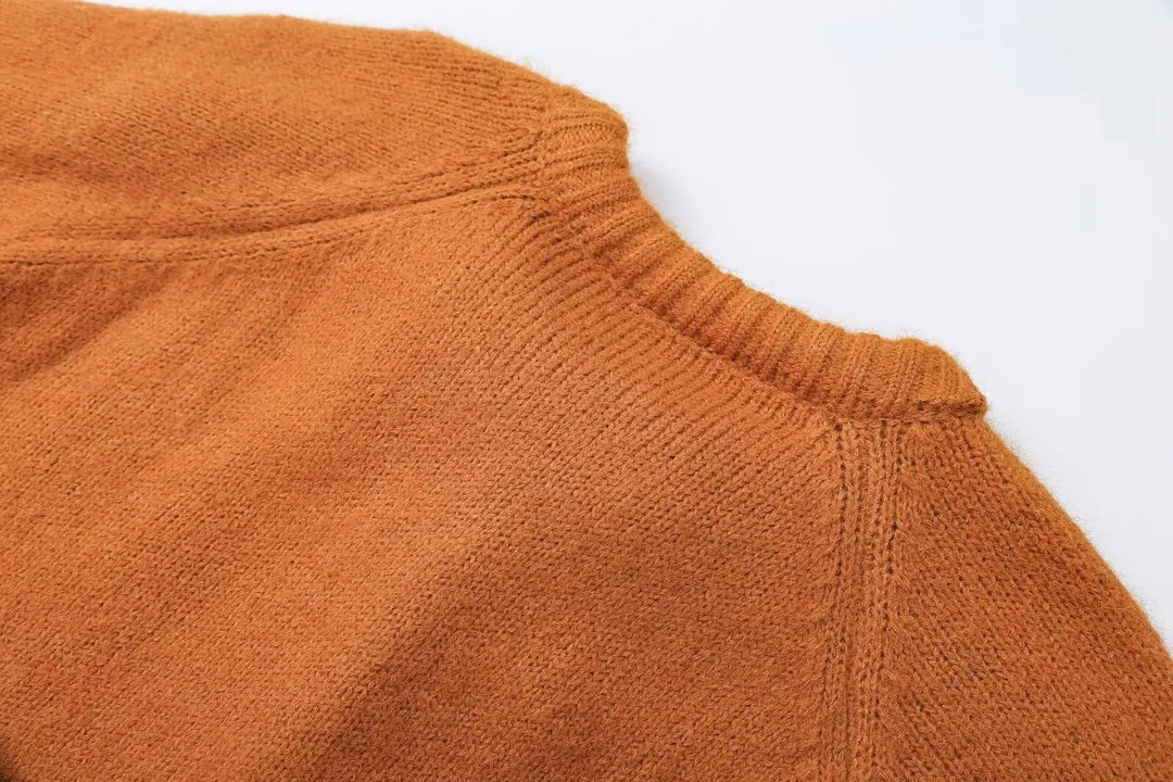 Orange ribbed neckline and knit texture on cropped cardigan