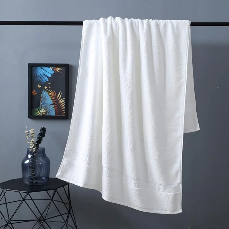 Bath towel in white, hanging flat with plush terry weave and smooth hem