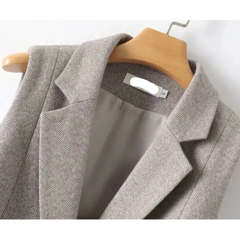 Gray herringbone waistcoat collar detail with inner label on a hanger
