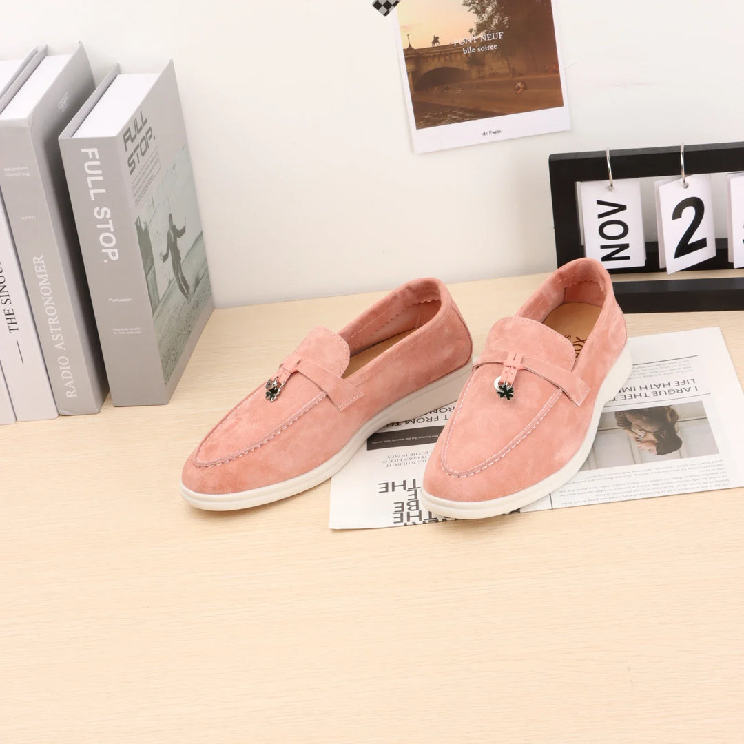 Light pink suede slip-on loafers with buckle strap and moc-toe stitching