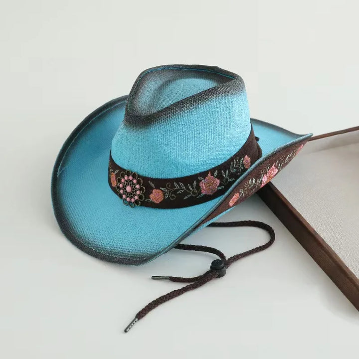 Embroidered cowboy sun hat, teal-blue with dark band and pink floral details, tie strings