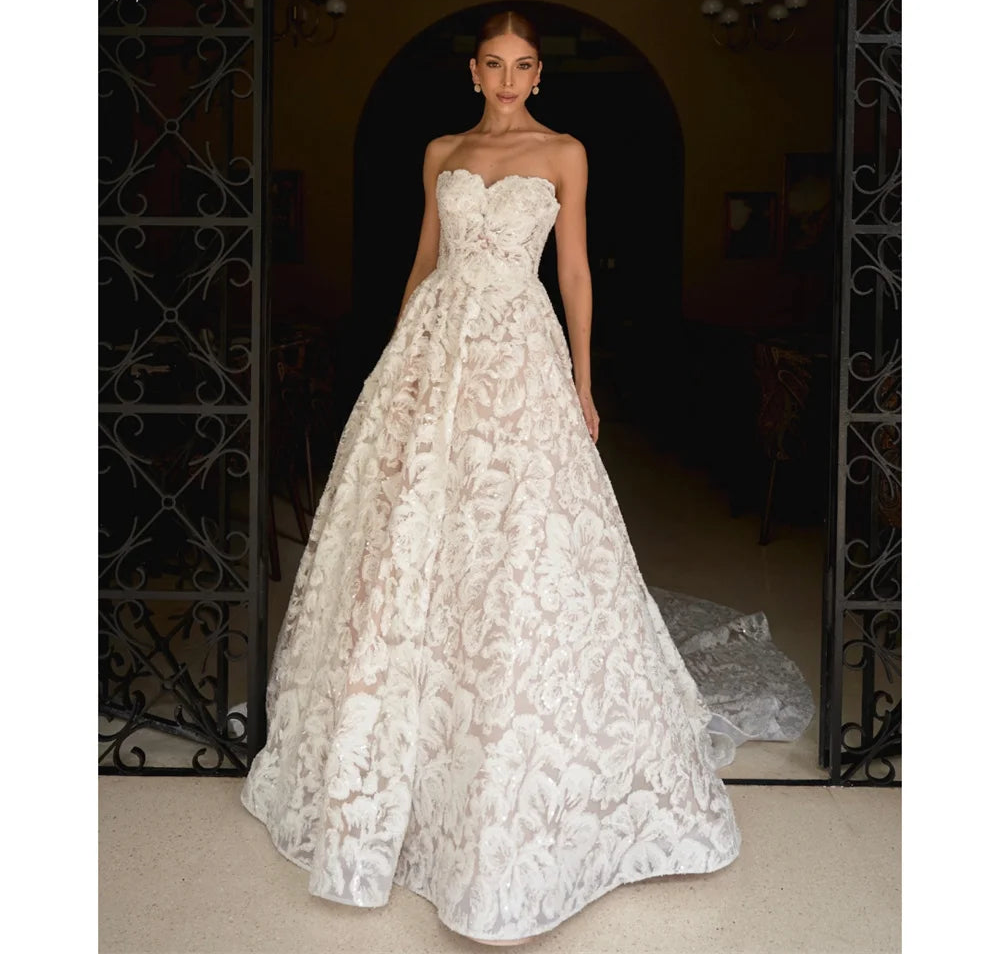 Woman wearing a white lace wedding dress standing in a doorway.
